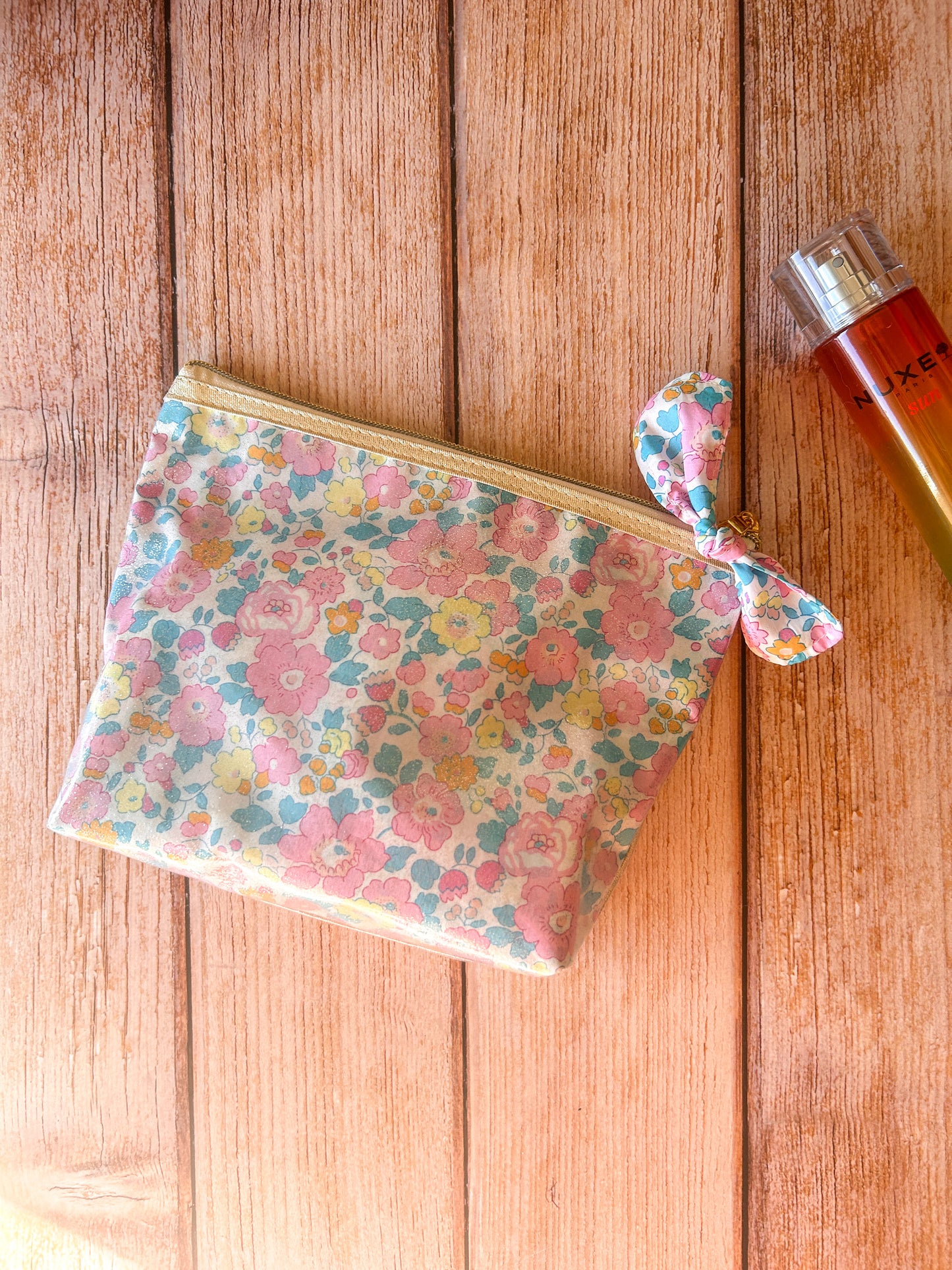 Trousse de voyage transparente en tissu Liberty fleuri pour ranger maquillage, produits de beauté et accessoires.